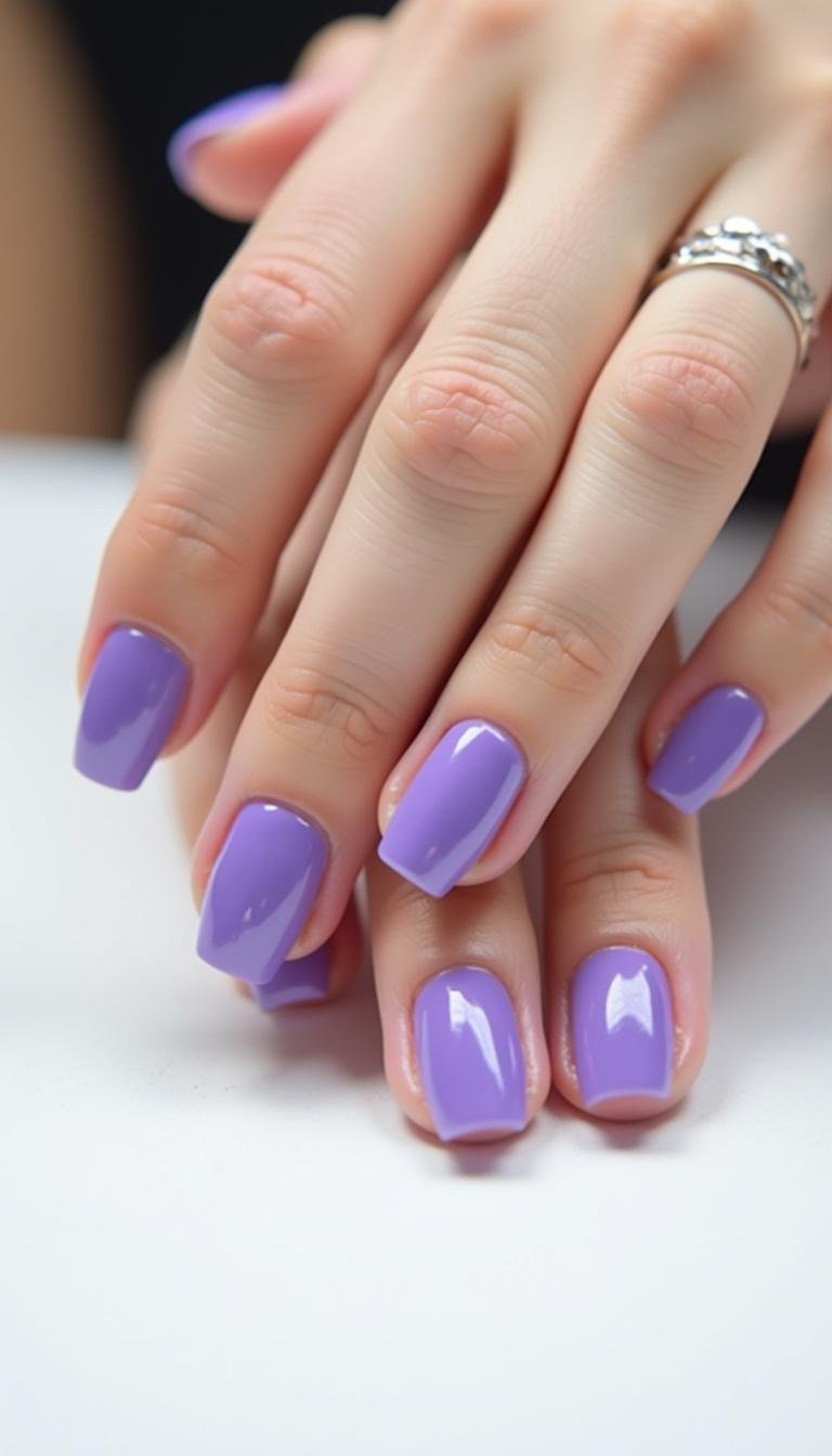 Minimalist purple gel nails with glossy finish on white background